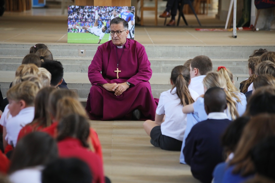 Bishop Jonathan talks to the Year 6 pupils, with the photo of Jude Bellingham behind him