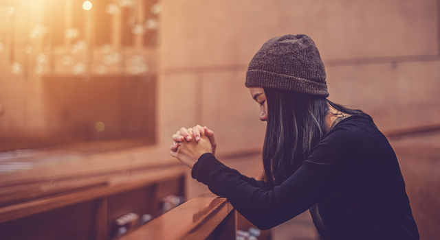 A young woman praying in a church