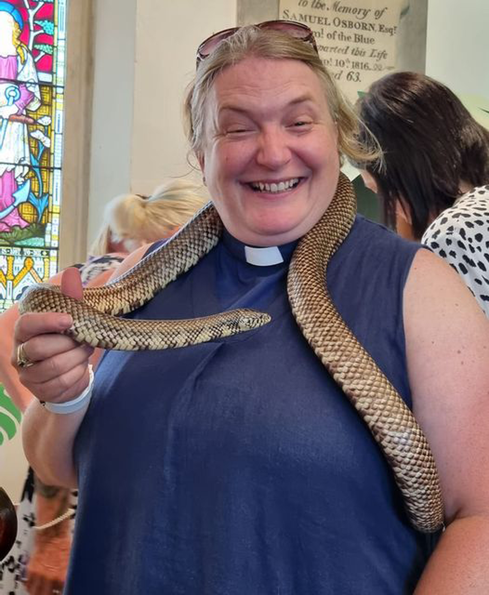Rev Amanda Collinson seems delighted to have a snake wrapped around her neck