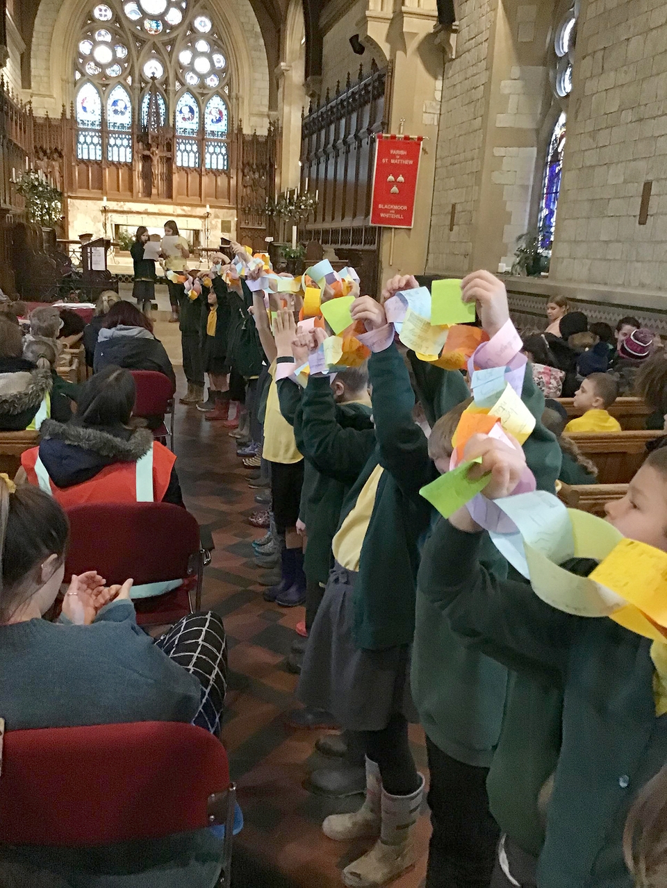 Children linking together their paper chains during the service at St Matthew’s Church, Blackmoor