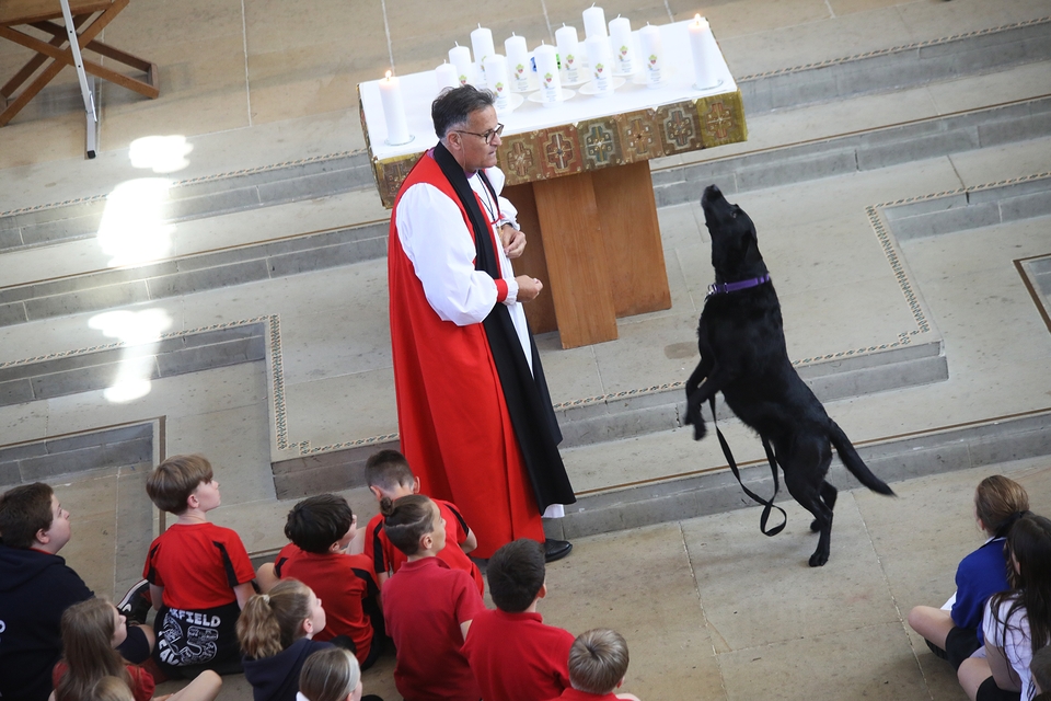 Bishop Jonathan and his dog Bonnie performing a trick in the Leavers' Service